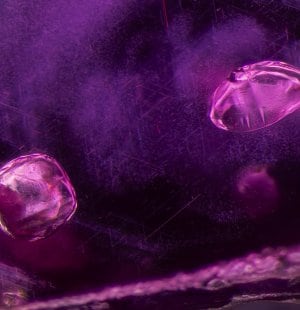 A pair of calcite crystals stand out against cloud of rutile sinlk in this ruby from Mogok, Burma., Ruby, Discover the Gemstones, L’ÉCOLE , School of Jewelry Arts, Singapore, Les Jardins Secret byVan Cleef & Aprels