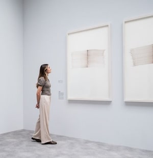 Une femme qui observe une œuvre au mur