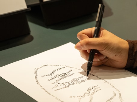 Focus on someone drawing a calligram