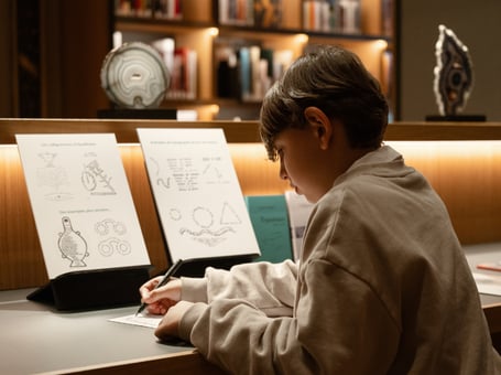 A boy is drawing in the library